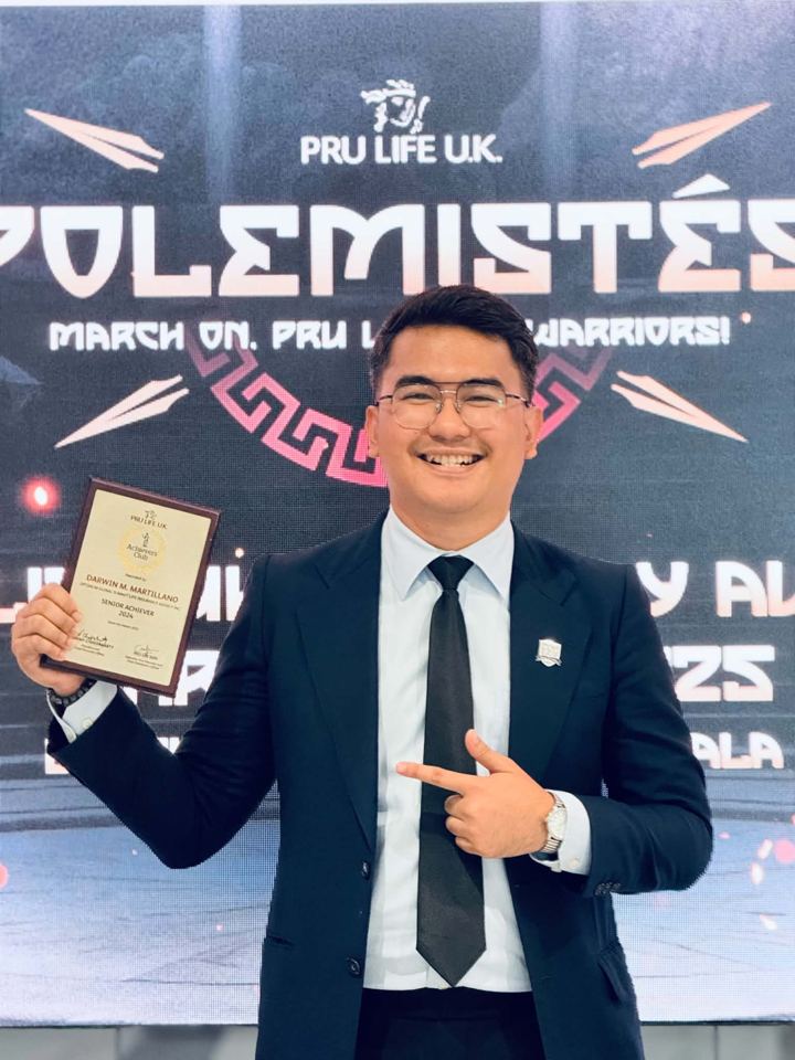 Darwin M. Martillano holding his Senior Achiever award